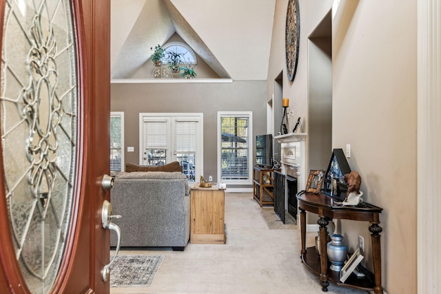 foyer with carpet floors and vaulted ceiling