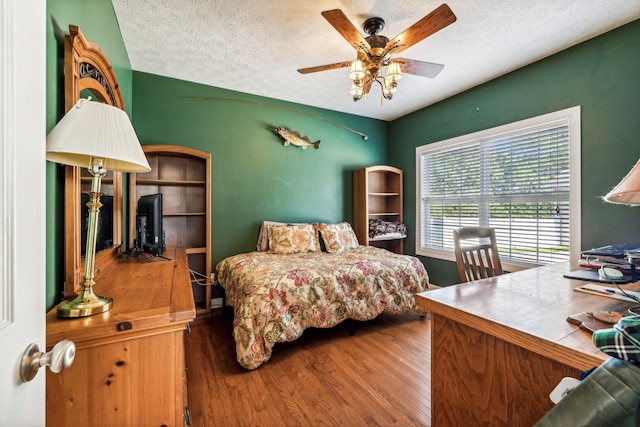 bedroom with ceiling fan, hardwood / wood-style floors, and a textured ceiling