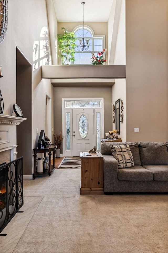 foyer entrance with a towering ceiling, carpet, and a notable chandelier