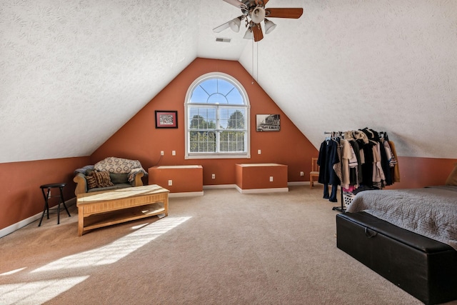 bedroom featuring ceiling fan, a textured ceiling, and light carpet