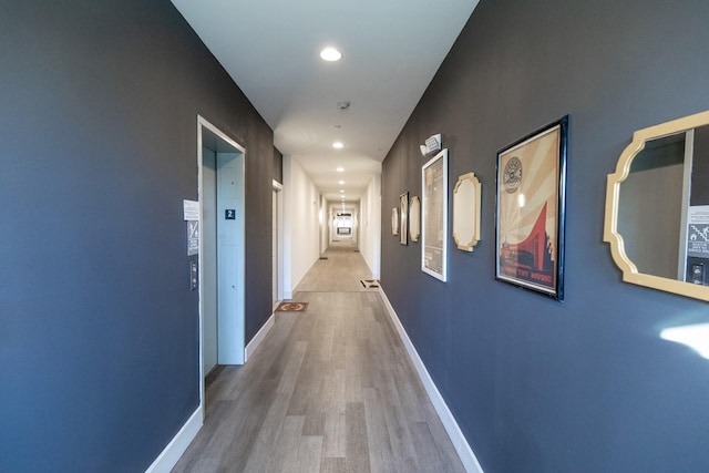 hallway with hardwood / wood-style floors