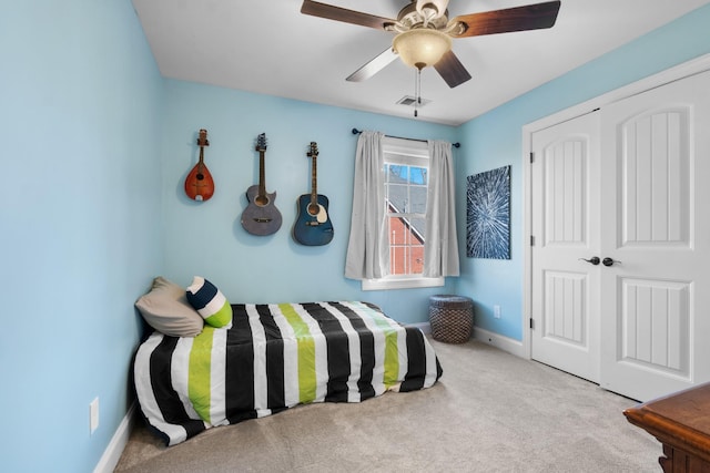 carpeted bedroom with ceiling fan and a closet