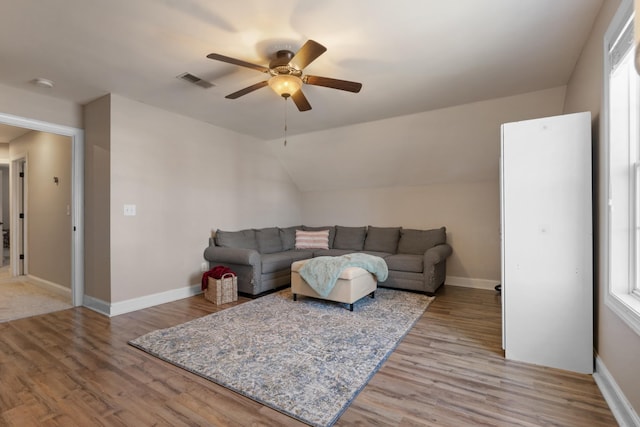 living room with ceiling fan, light wood-type flooring, and lofted ceiling