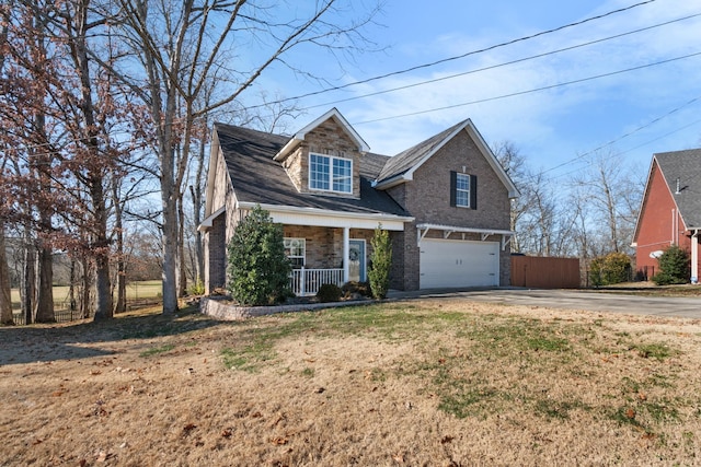 view of front of property with a garage, a front lawn, and covered porch