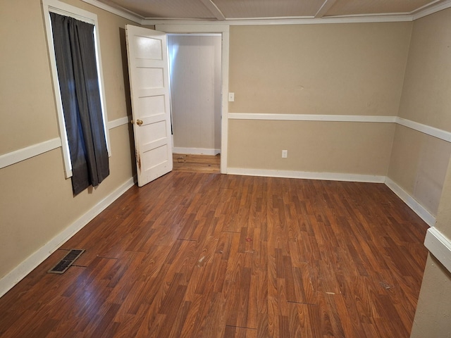 unfurnished room with crown molding and dark wood-type flooring