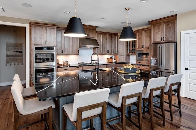 kitchen featuring a kitchen breakfast bar, hanging light fixtures, and stainless steel appliances