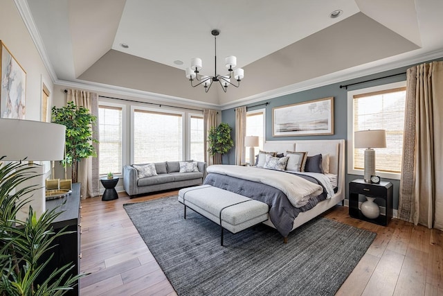 bedroom featuring a notable chandelier, hardwood / wood-style floors, crown molding, and a tray ceiling