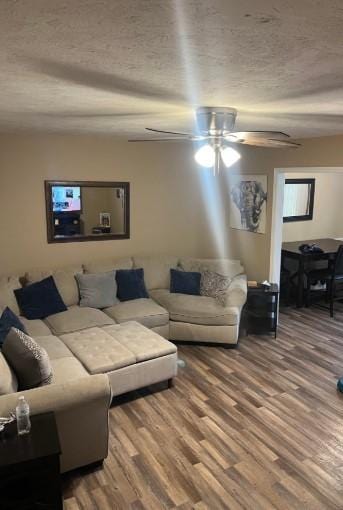 living room with wood-type flooring, a textured ceiling, and ceiling fan