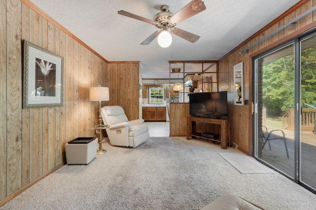 sitting room featuring plenty of natural light, light colored carpet, ceiling fan, and ornamental molding