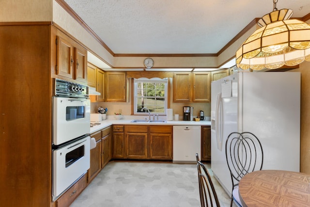 kitchen featuring sink, white appliances, crown molding, and pendant lighting