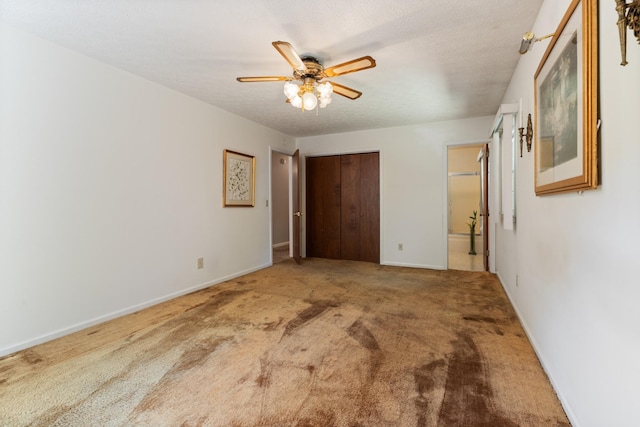 unfurnished bedroom featuring ceiling fan, carpet, a closet, and a textured ceiling