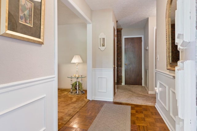 corridor featuring dark parquet floors and a textured ceiling