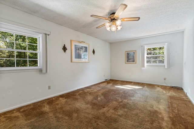 carpeted empty room featuring ceiling fan and a textured ceiling