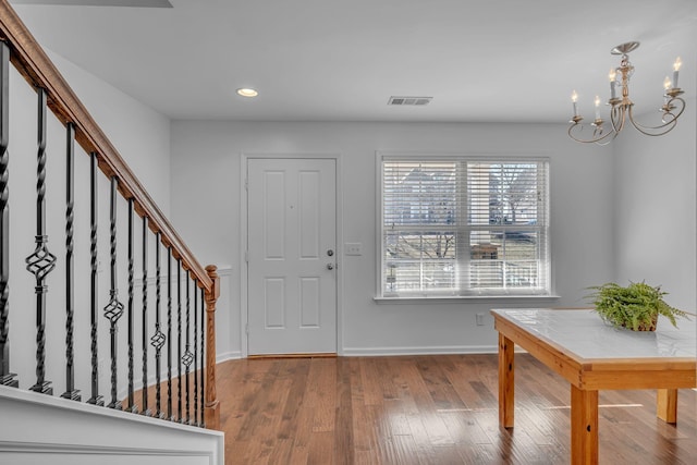 foyer with wood-type flooring and an inviting chandelier