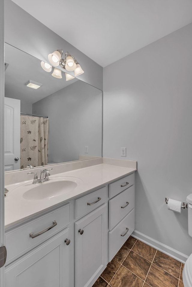 bathroom with curtained shower, toilet, and vanity