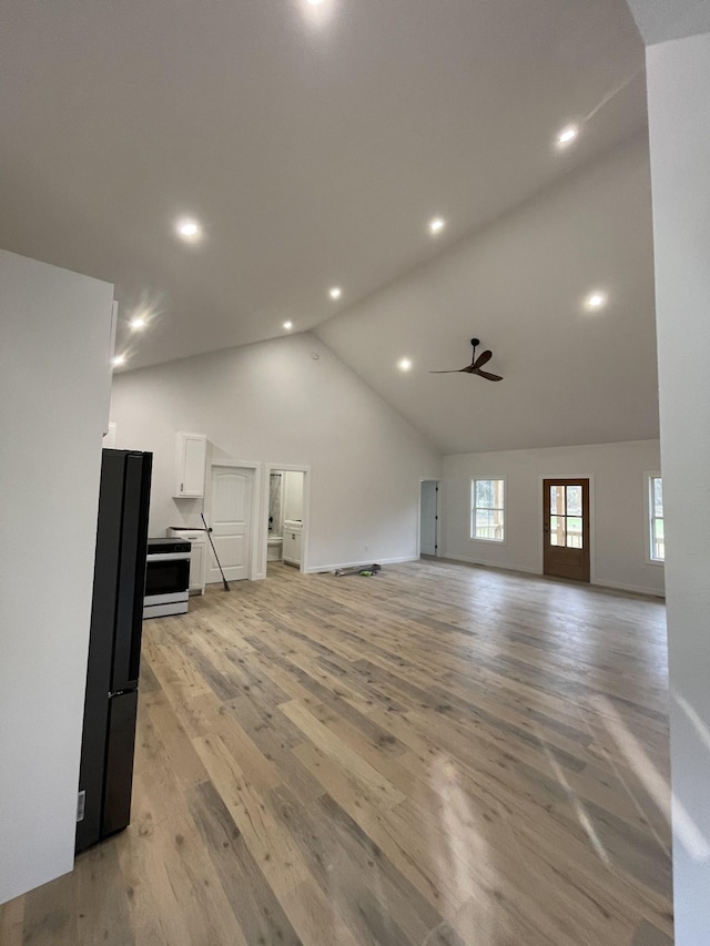 unfurnished living room with high vaulted ceiling, light hardwood / wood-style floors, and ceiling fan