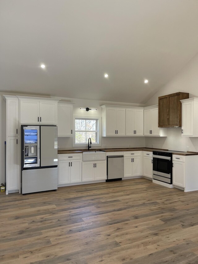 kitchen with white fridge with ice dispenser, dishwasher, white cabinets, sink, and electric range oven