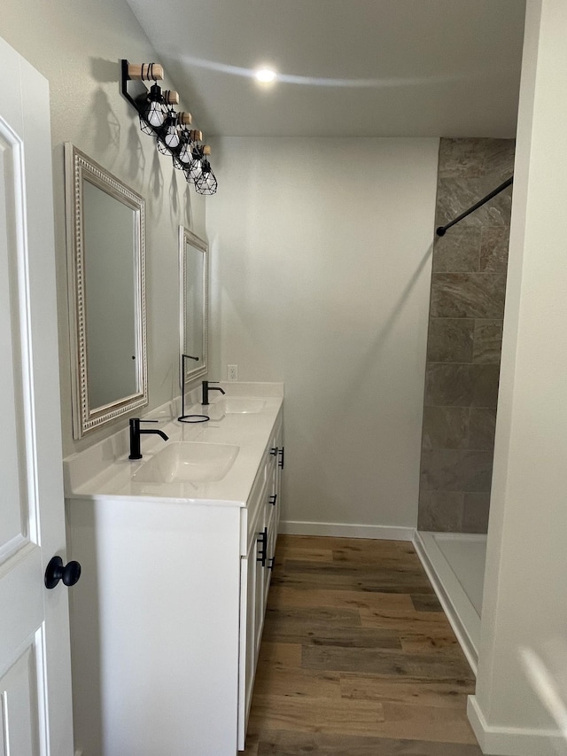 bathroom with wood-type flooring, a shower, and vanity