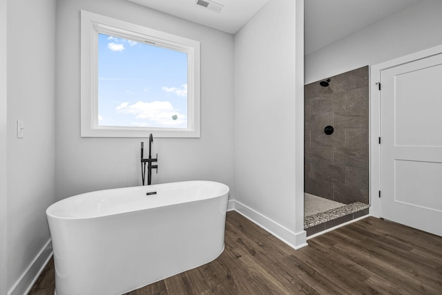 bathroom with hardwood / wood-style floors and independent shower and bath