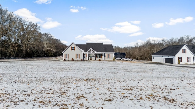 view of front of home with a porch, a garage, and an outbuilding