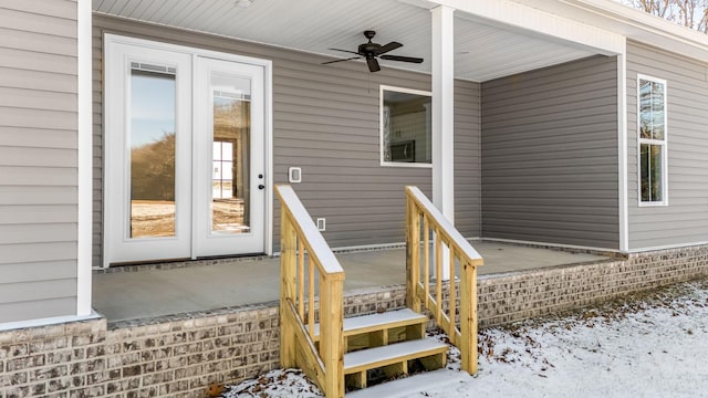 snow covered property entrance with ceiling fan and french doors