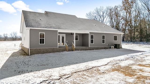 snow covered house featuring central AC unit and ceiling fan