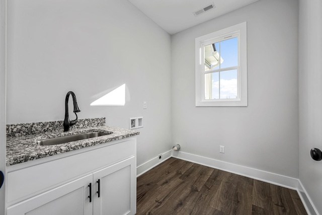 clothes washing area with sink, hookup for a washing machine, dark hardwood / wood-style floors, and cabinets