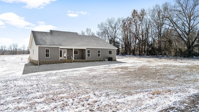 view of snow covered rear of property