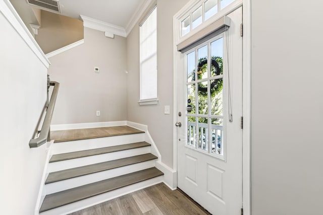 entryway with hardwood / wood-style flooring and crown molding