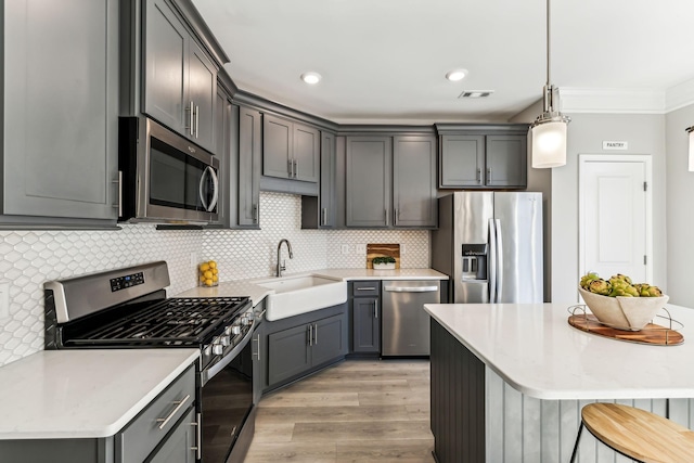 kitchen with sink, gray cabinets, hanging light fixtures, and stainless steel appliances