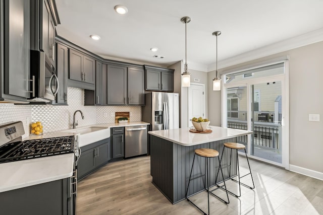 kitchen with a center island, decorative light fixtures, stainless steel appliances, backsplash, and ornamental molding