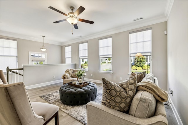 living room featuring light wood-type flooring, ceiling fan, and crown molding