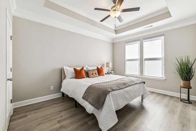 bedroom featuring ceiling fan, a raised ceiling, and crown molding