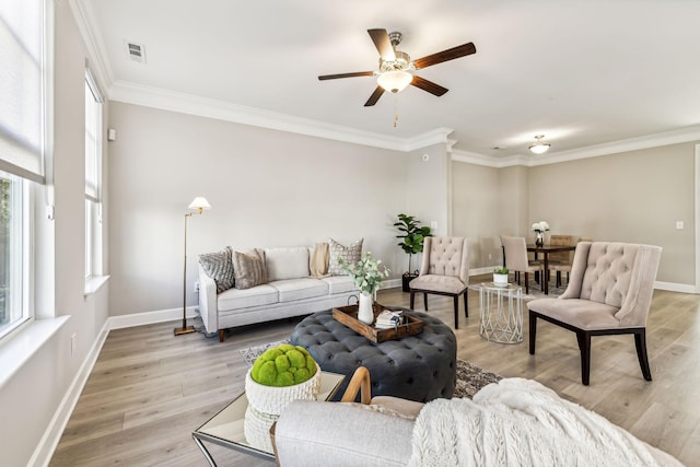 living room featuring light hardwood / wood-style flooring, ceiling fan, and ornamental molding