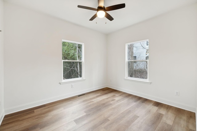 empty room featuring ceiling fan, light hardwood / wood-style flooring, and plenty of natural light