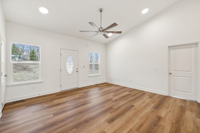 foyer entrance with ceiling fan, wood-type flooring, and vaulted ceiling