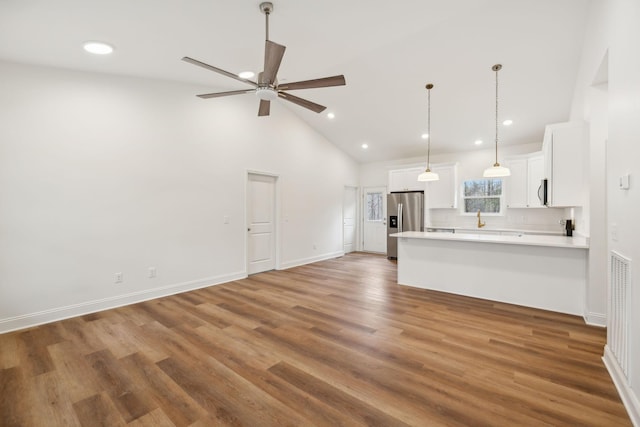 unfurnished living room with dark hardwood / wood-style floors, high vaulted ceiling, and ceiling fan