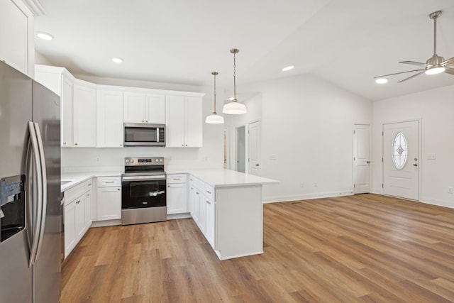 kitchen with vaulted ceiling, white cabinetry, hanging light fixtures, kitchen peninsula, and stainless steel appliances