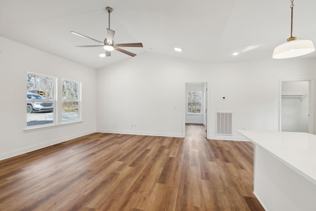 unfurnished living room with ceiling fan, lofted ceiling, and wood-type flooring