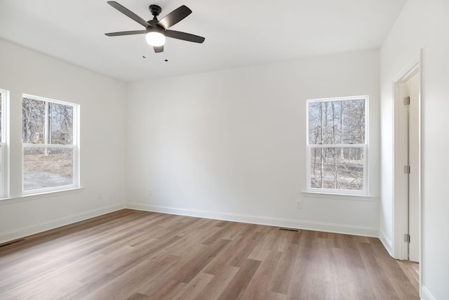 empty room featuring ceiling fan, light hardwood / wood-style flooring, and plenty of natural light