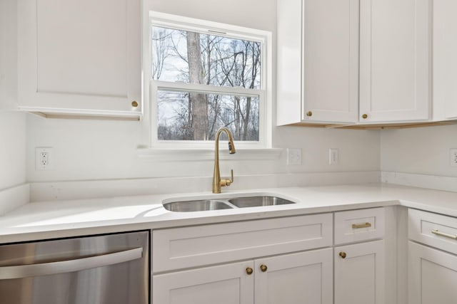 kitchen featuring sink, stainless steel dishwasher, and white cabinetry