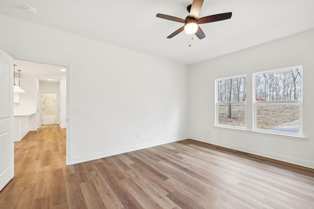 empty room featuring light wood-type flooring and ceiling fan