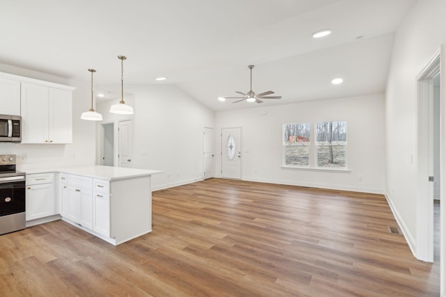 kitchen with kitchen peninsula, light wood-type flooring, white cabinetry, and stainless steel appliances