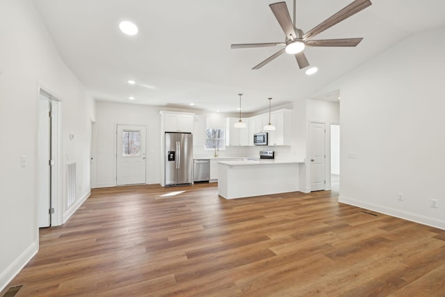 unfurnished living room with wood-type flooring, ceiling fan, and lofted ceiling