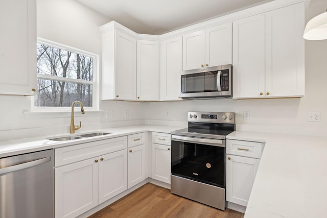 kitchen featuring light hardwood / wood-style floors, sink, white cabinetry, and stainless steel appliances