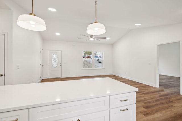 kitchen featuring dark wood-type flooring, white cabinetry, and hanging light fixtures