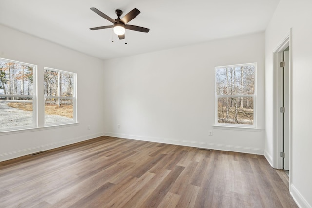 unfurnished room with plenty of natural light, light wood-type flooring, and ceiling fan