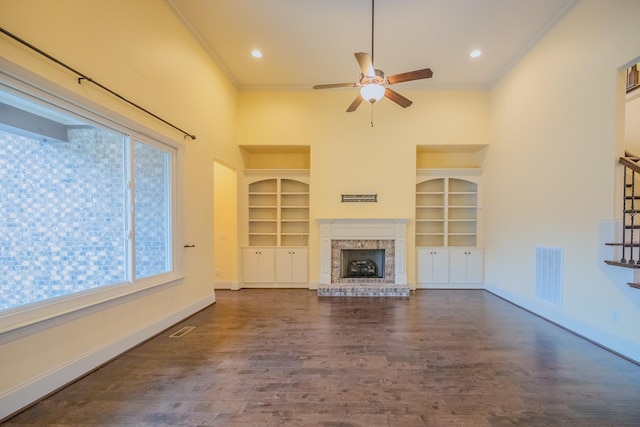 unfurnished living room with a brick fireplace, crown molding, dark hardwood / wood-style floors, and ceiling fan