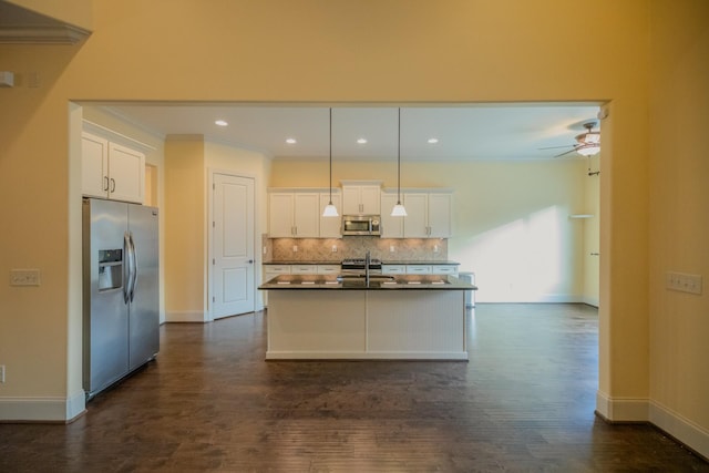 kitchen with white cabinetry, pendant lighting, stainless steel appliances, a kitchen island with sink, and decorative backsplash