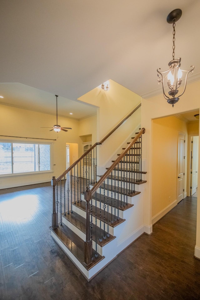 stairway featuring hardwood / wood-style flooring and ceiling fan with notable chandelier